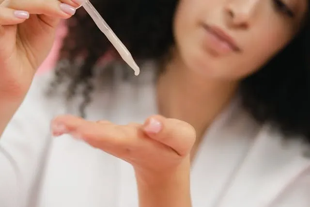 Gouttes de sérum hydratant déposées dans le creux d’une main avec une pipette, gros plan sur un soin cosmétique fluide et naturel