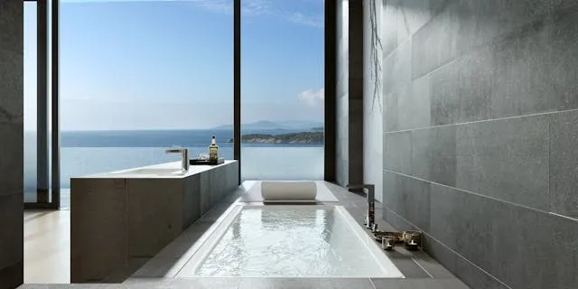 Salle de bain design avec baignoire encastrée face à la mer, architecture épurée et vue panoramique