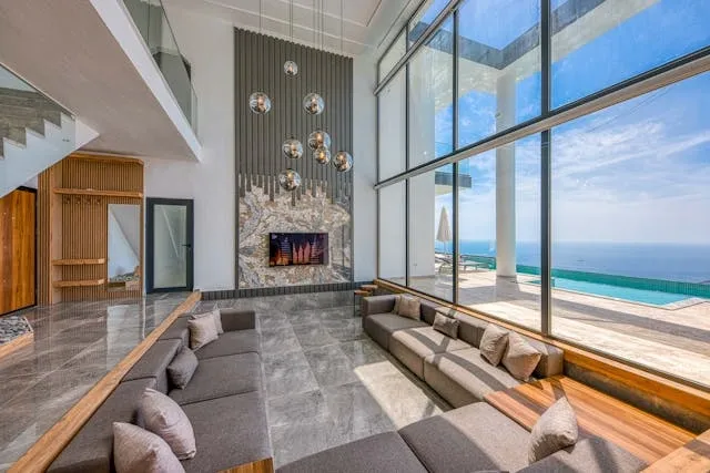 Salon contemporain avec mobilier moderne, grandes baies vitrées et vue dégagée sur la mer" 🏷️ Nom de fichier suggéré