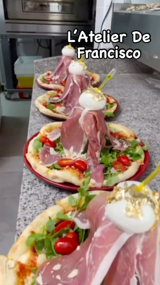 Pizza gourmande à la burrata et jambon cru servie par L’Atelier de Francisco – spécialité italienne revisitée avec finesse, 2025.