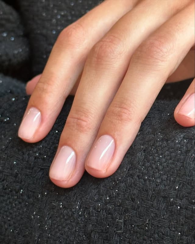 Manucure nude minimaliste signée Lauren Hazel Broe – ongles courts au fini brillant et naturel, tendance onglerie 2025.