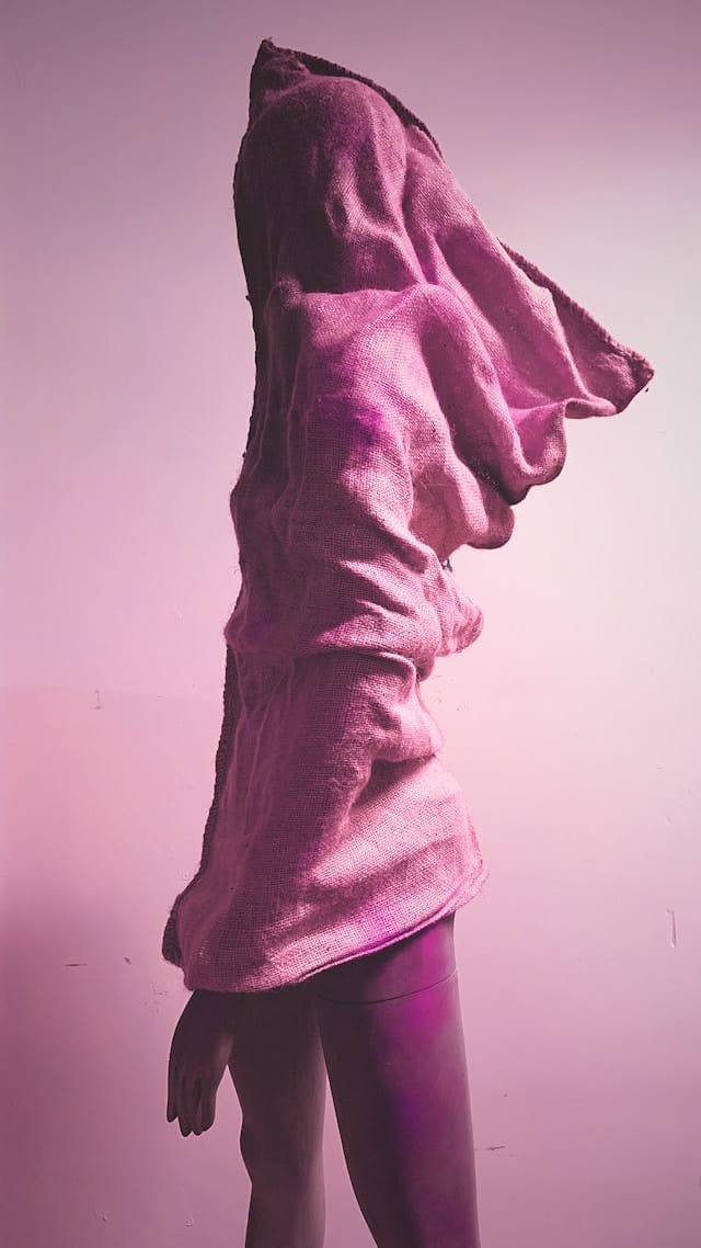 silhouette artistique drapée dans un tissu rose, ambiance conceptuelle et onirique