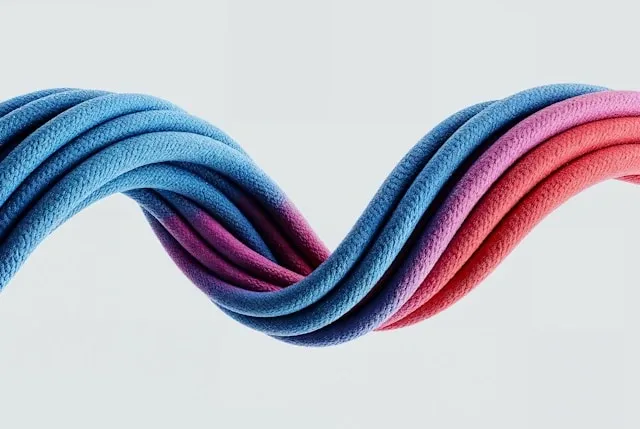 Torsade de textiles aux couleurs vibrantes bleu, violet et rose, composition design contemporaine sur fond clair