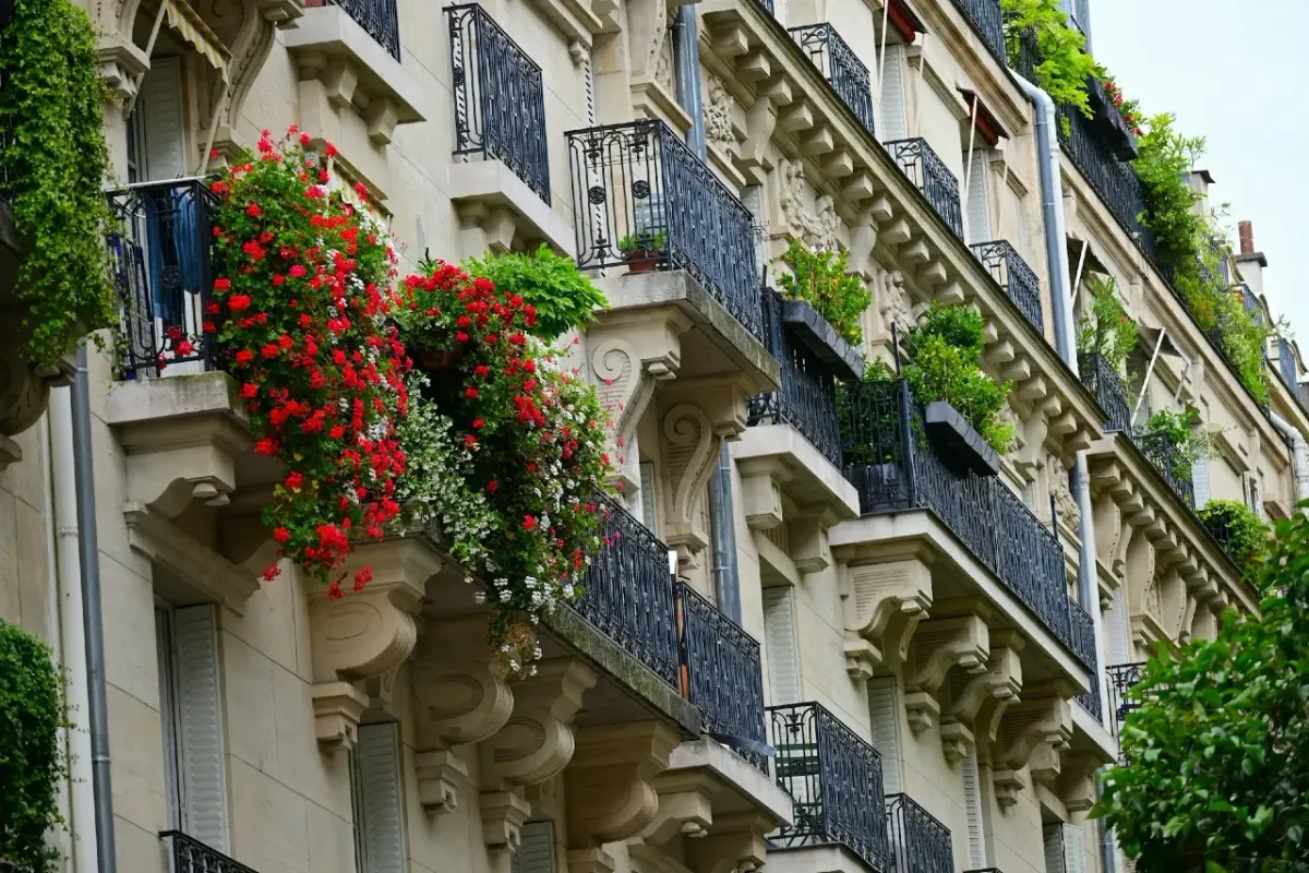 Façade d’immeuble haussmannien à Paris avec balcons fleuris et architecture élégante