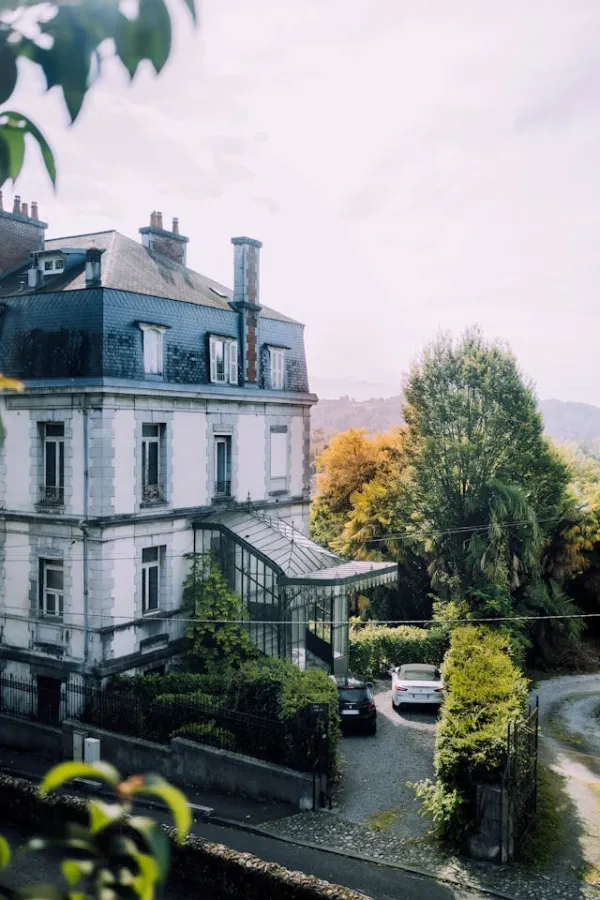 Maison ancienne de style bourgeois avec toit en ardoise, jardin arboré et façade XIXe en pierre, au cœur de la campagne française