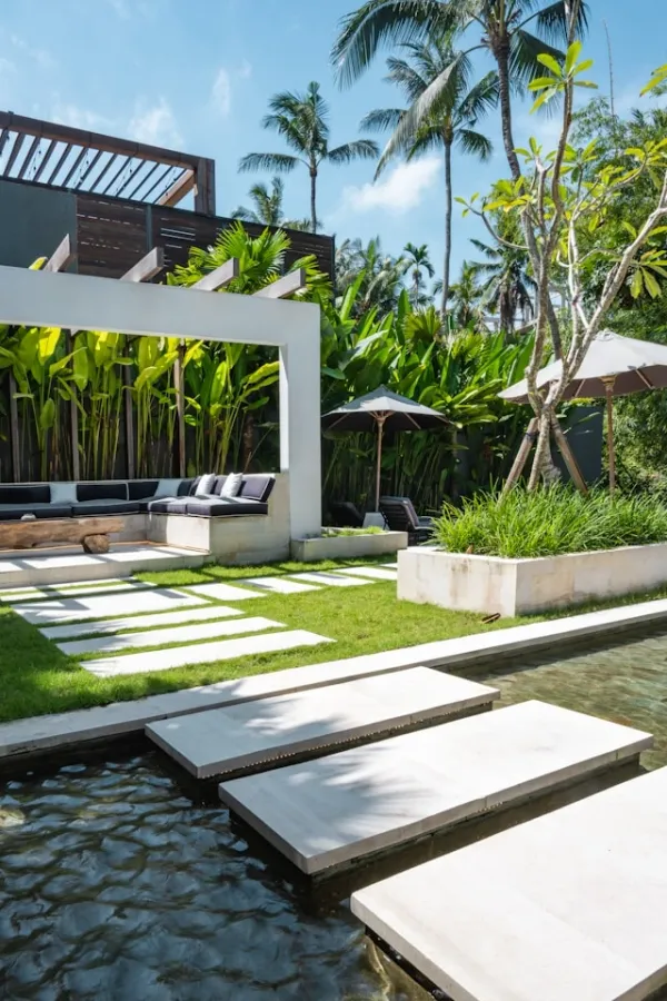 Un jeu d’ombres, d’eau et de béton blanc anime la sérénité tropicale d’un jardin design.