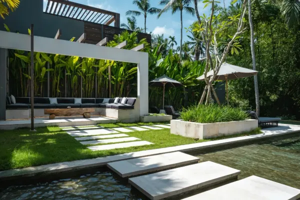 Terrasse moderne avec piscine et mobilier design dans un jardin tropical luxuriant